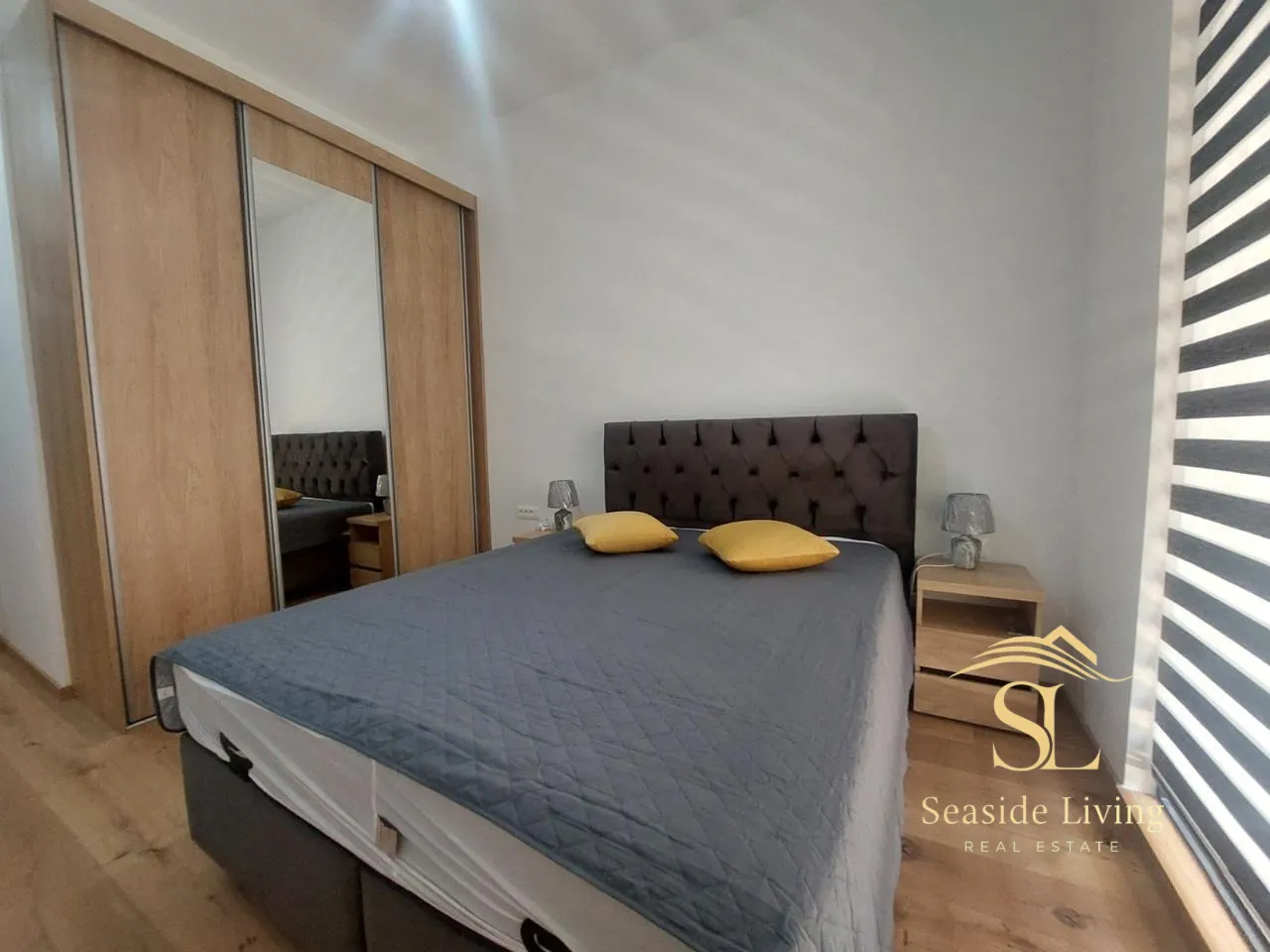 Bedroom with a double bed, mirrored wardrobe, and nightstands.