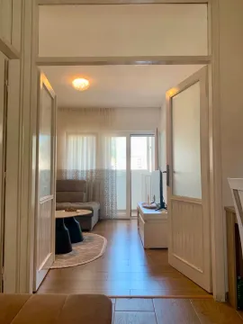 View of the bright living room through open doors from the hallway. - image 3