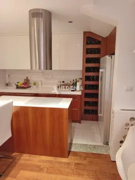 Moderna kuhinja sa šankom, ugradnim elementima i policama za vino. - image 6