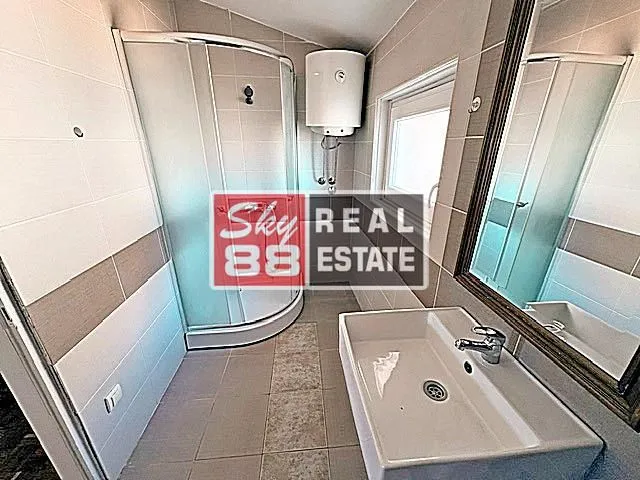 Bathroom equipped with a shower cabin, washbasin, and water heater.