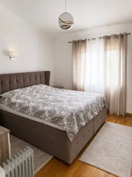 Furnished bedroom with a double bed, window, and curtains. - image 4