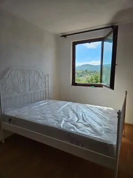 Bedroom with a white metal bed and an open window with a view of nature. - image 7
