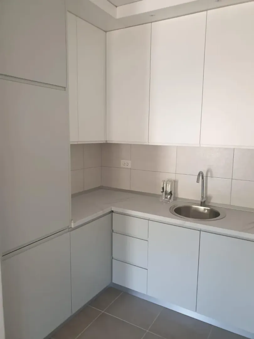 Moderna kuhinja sa bijelim i sivim elementima.