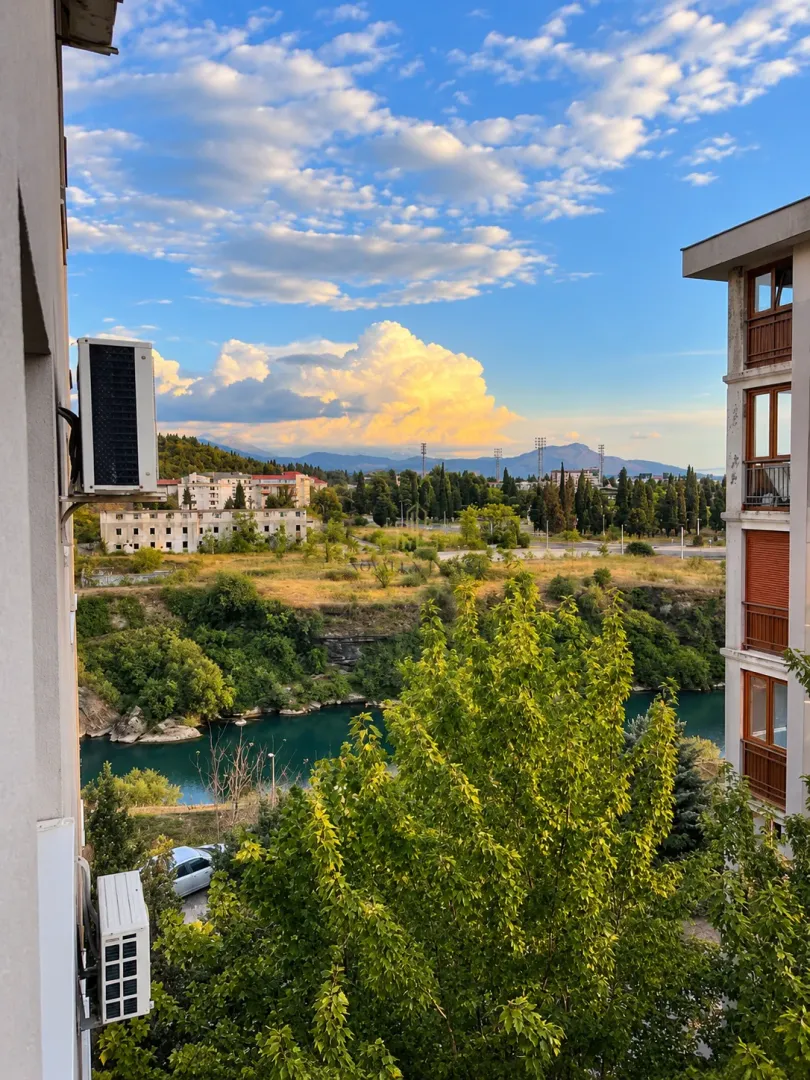 View from the window of the river, greenery, and the city in the distance.