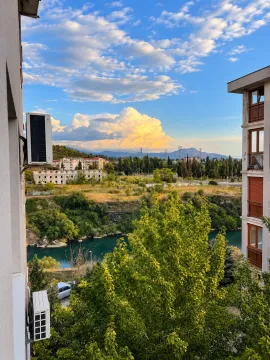 View from the window of the river, greenery, and the city in the distance. - image 8