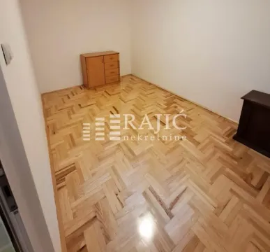 Empty room with parquet flooring and a small piece of furniture. - image 11
