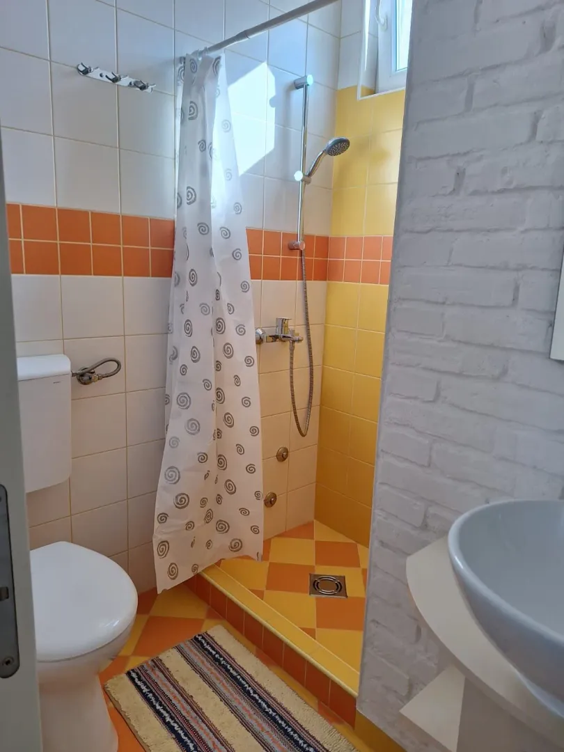 Bathroom with a shower cabin, sink, and toilet.
