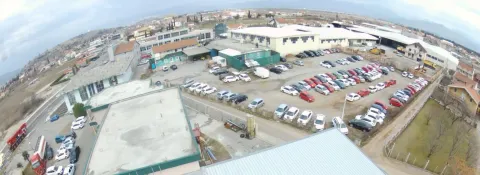 A wide-angle view of a commercial complex featuring a large parking lot and surrounding buildings. - image 5