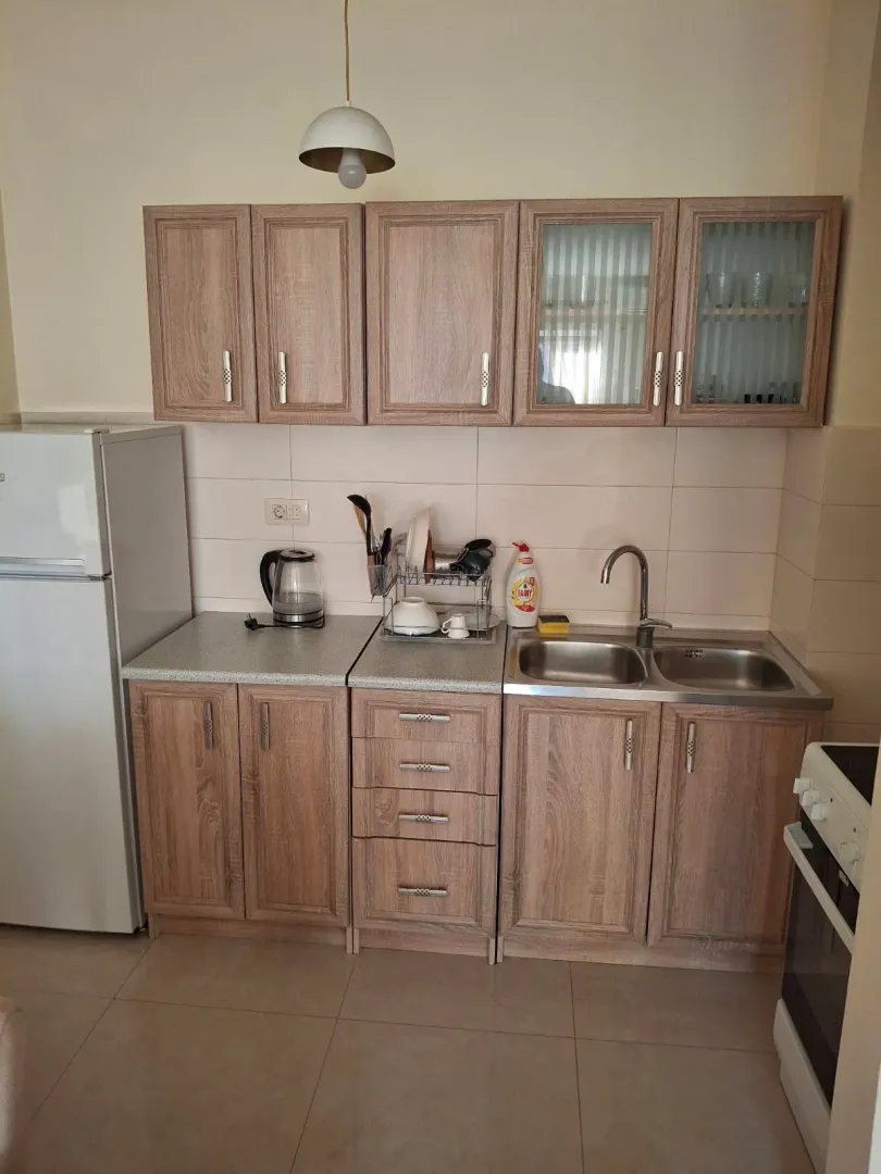 Small kitchen with wooden cabinetry, sink, and built-in appliances.