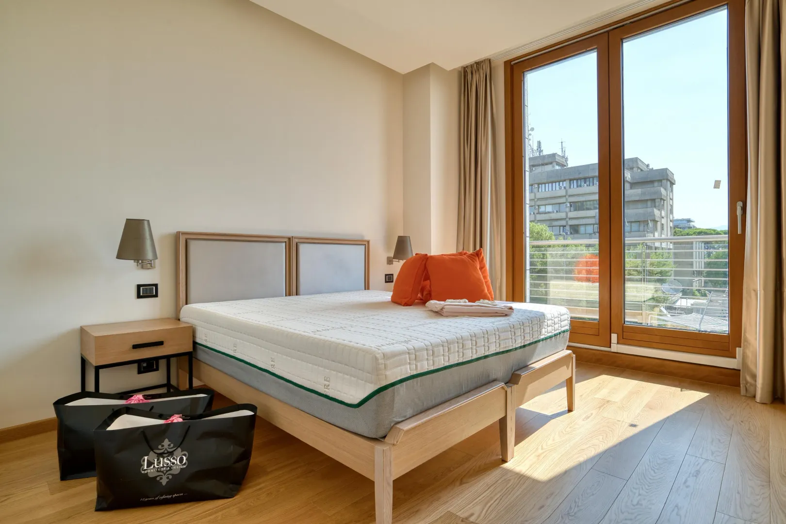 Bright and spacious bedroom with a double bed and large balcony doors.