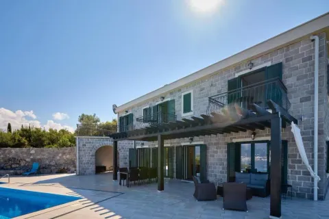 Exterior of a stone house with a swimming pool and terrace. - image 14