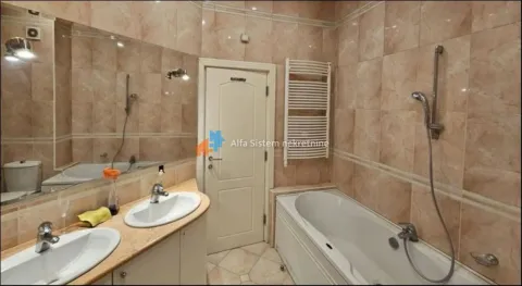 Tiled bathroom with a bathtub and double vanity sink. - image 8