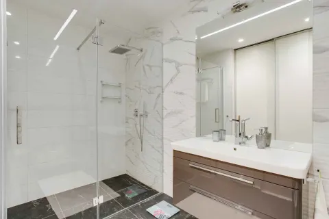 Moderno kupatilo sa staklenom tuš kabinom i elegantnim lavaboom sa ogledalom. - image 7