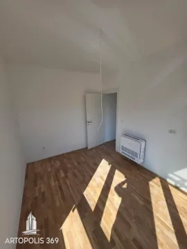 Empty room with wooden flooring, an air conditioning unit, and an open door. - image 15