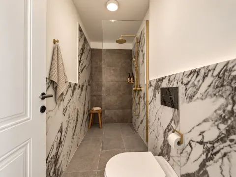 Moderne kupatilo sa tuš kabinom i zlatnim slavinama. - image 9