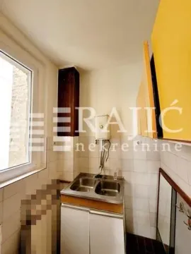 Smaller kitchen with a sink, window, and yellow hanging cabinets. - image 5