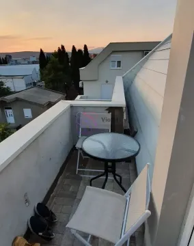 Manji balkon sa stolom i dve stolice i pogledom na okolinu. - image 6