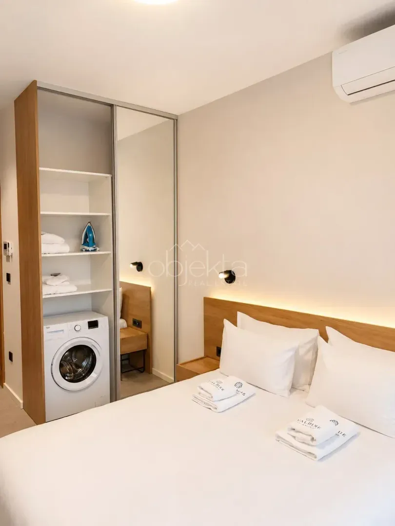 Bedroom with a double bed, built-in wardrobe, and washing machine.