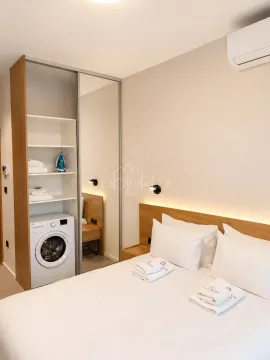 Bedroom with a double bed, built-in wardrobe, and washing machine. - image 10