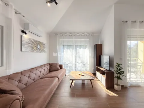 Dnevna soba sa braon kožnom garniturom, drvenim stočićem i TV komodom. - image 3