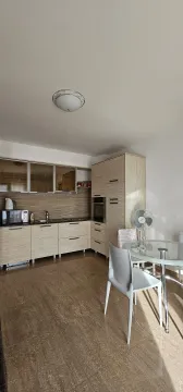 Moderna kuhinja sa drvenim elementima i trpezarijskim stolom. - image 4