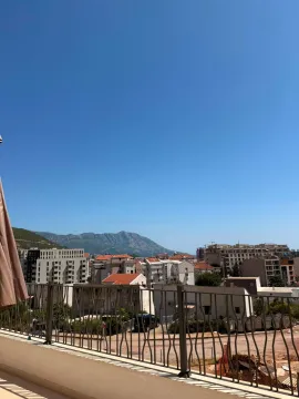 View from the terrace towards the surrounding buildings and hills in the distance. - image 11