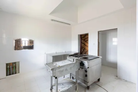 Commercial kitchen with stainless steel elements and white wall tiles. - image 6