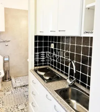 Small kitchen combined with a bathroom in bright tones with white elements. - image 8