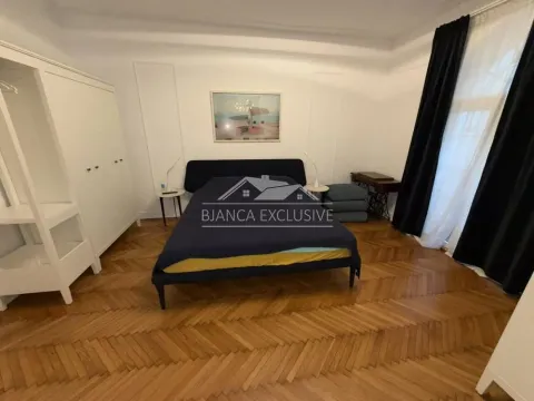 Nameštena spavaća soba sa bračnim krevetom, belim garderoberom i drvenim parketom. - image 7