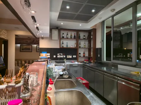 Bar counter with sink and drink shelves in a commercial property. - image 6