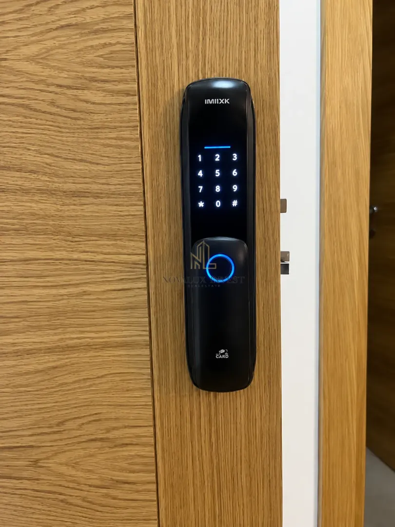 Moderna elektronska brava sa tastaturom i čitačem otiska prsta na drvenim vratima.
