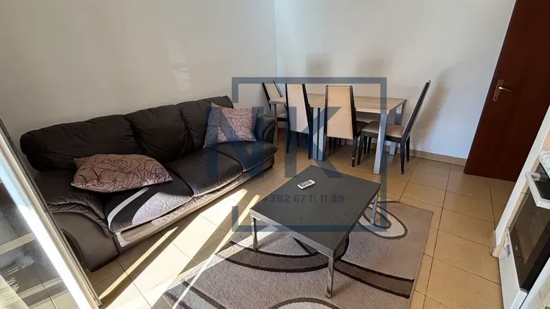 Living room with a sofa, coffee table, and dining table.