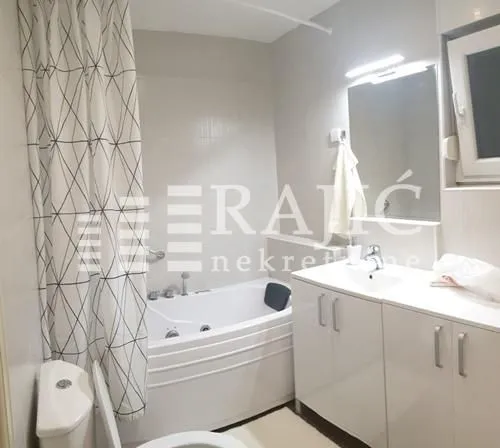 Small bathroom with a bathtub, washbasin, and toilet.