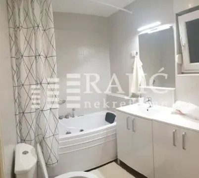 Small bathroom with a bathtub, washbasin, and toilet. - image 3