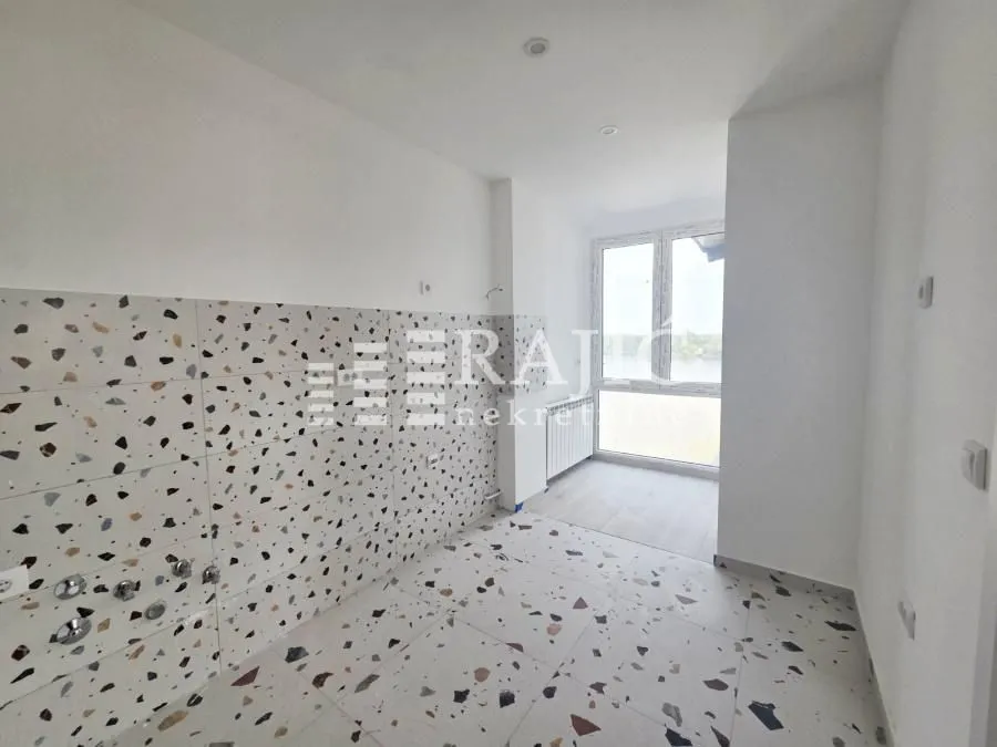 Empty kitchen with ceramic tiles and river view.