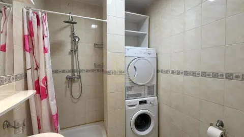 Kupatilo obloženo keramičkim pločicama sa tuš kabinom i veš mašinom. - image 9