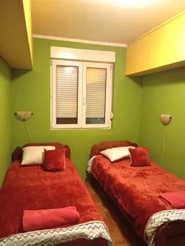 Spavaća soba sa dva kreveta za jednu osobu i zelenim zidovima. - image 4