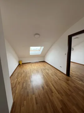 Empty attic room with a skylight and wooden parquet flooring. - image 16