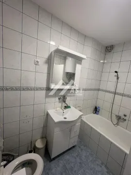 Kupatilo opremljeno umivaonikom, kadom, wc šoljom i ogledalom sa ormarićem. - image 8