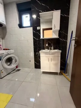 Bathroom with a sink, mirror, washing machine, and ceramic tiles. - image 7
