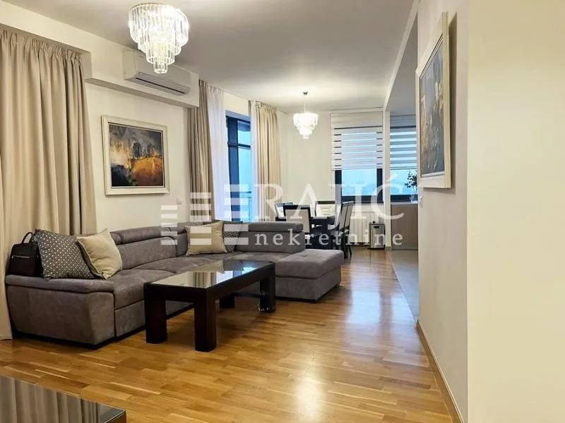 Spacious living room with a sofa set and a dining area in the background.