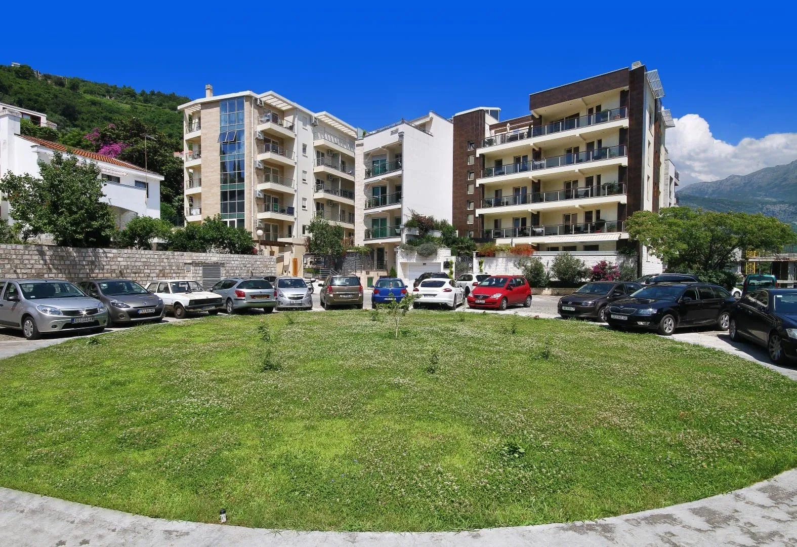Exterior view of residential buildings with a landscaped yard and parking lot.