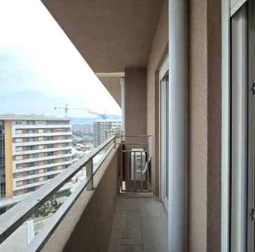 Dugačka terasa sa metalnom ogradom i pogledom na grad. - image 6