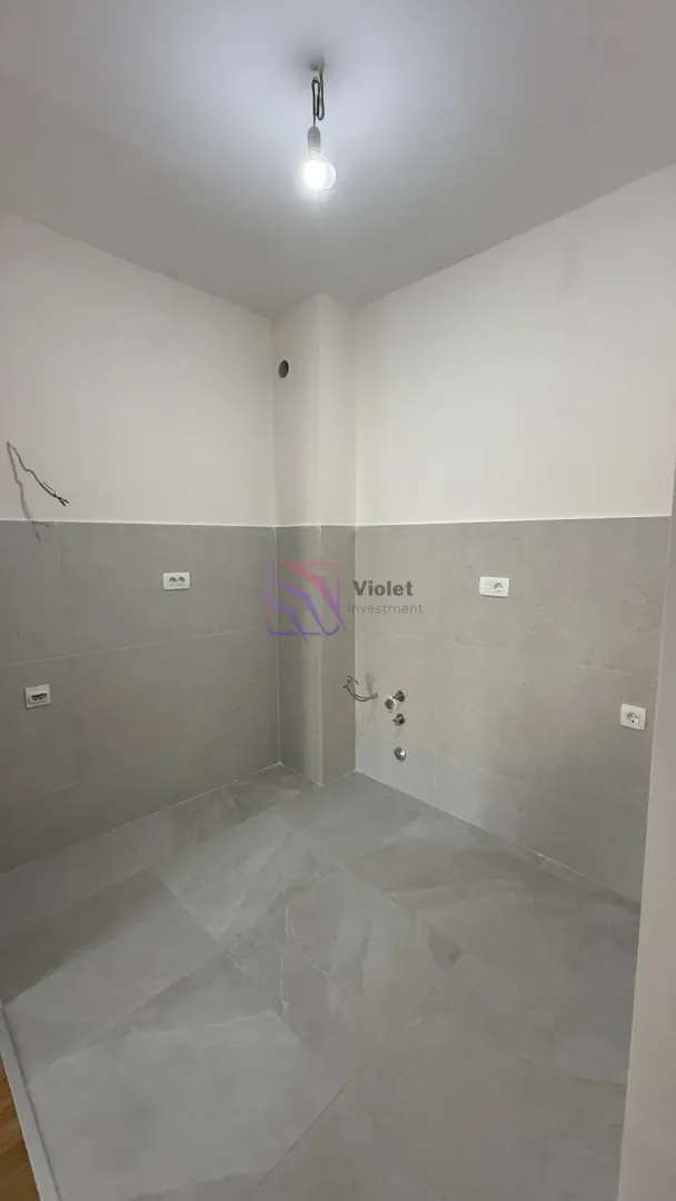 Unfurnished room with tiles on the lower part of the walls and utility installations.