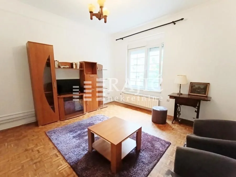 Dnevna soba sa garniturom i drvenim nameštajem.