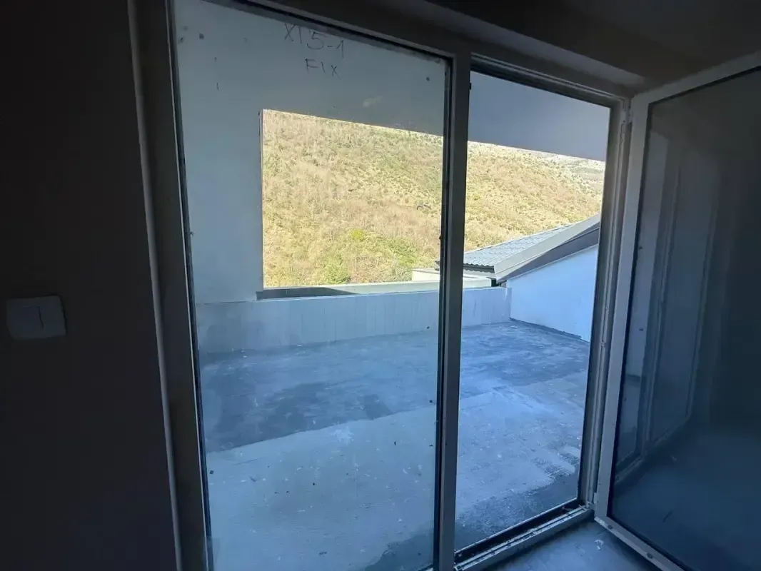 Pogled na prostranu terasu sa izlazom iz sobe.