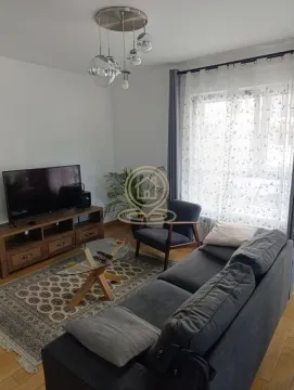 Living room furnished with a sofa, TV, and coffee table. - image 2