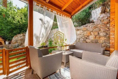Covered terrace with seating furniture and a view of greenery. - image 10