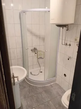 Smaller bathroom with a shower cabin, washbasin, and water heater. - image 2