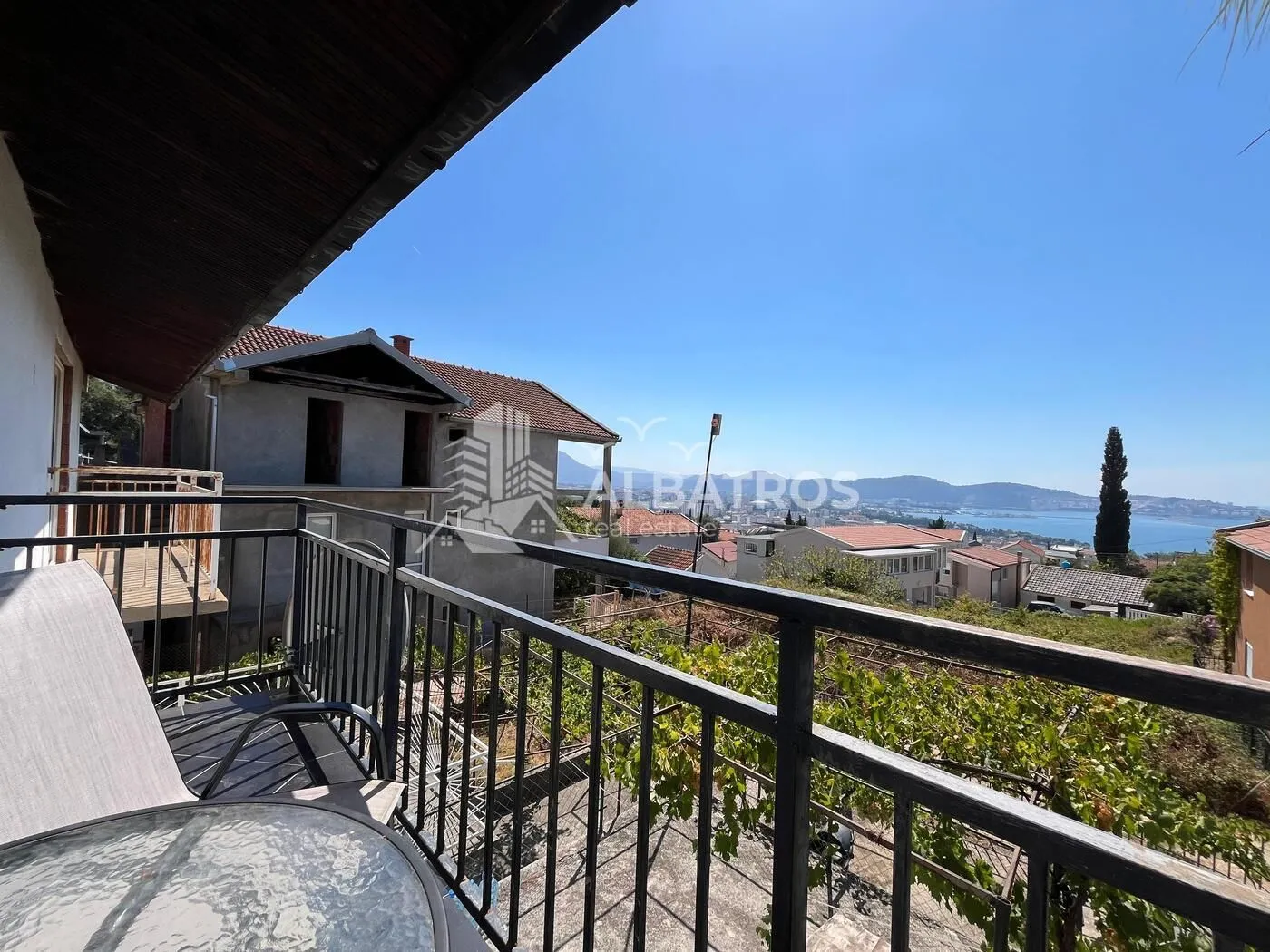 View from the covered balcony towards the sea and surrounding buildings.